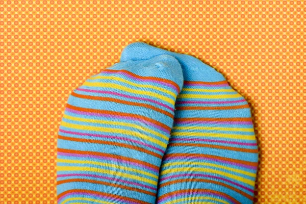 Someone rubbing his or her feet wearing colorful socks — Stock Photo, Image