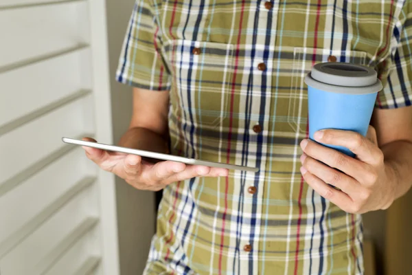 Pria dengan secangkir kopi atau teh menggunakan tablet — Stok Foto