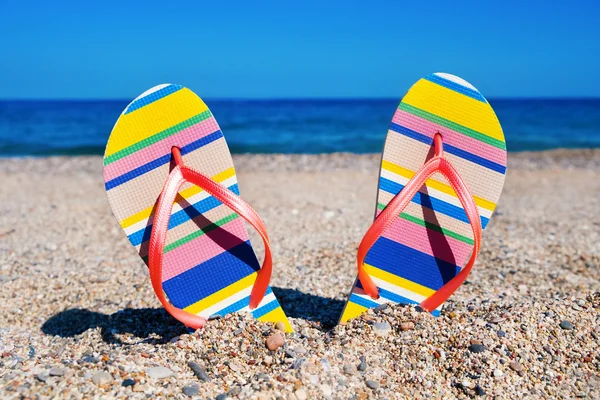 Chanclas en la arena de una playa — Foto de Stock