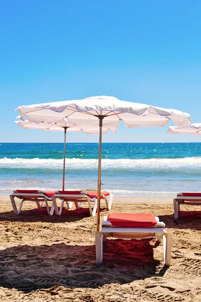 Sunloungers and umbrellas in a quiet beach — Stock Photo, Image