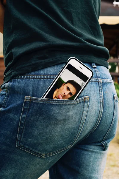 Man steekt zijn tong uit in een smartphone — Stockfoto