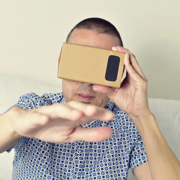 Jovem usando lentes de realidade virtual de papelão — Fotografia de Stock