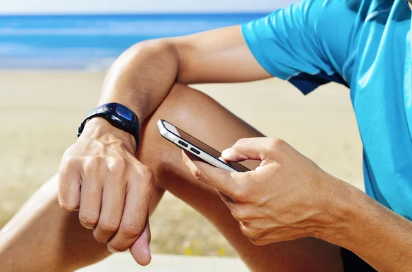 Joven deportista sincronizando su smartwatch — Foto de Stock