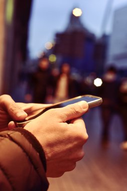 genç adam onun smartphone sokakta geceleri kullanarak.