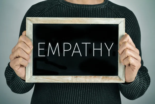 Man with a chalkboard with the text empathy — Stock Photo, Image