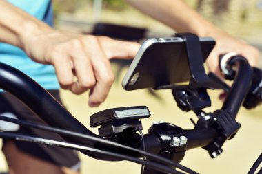 bir bisiklet sürme bir akıllı telefon kullanan genç adam