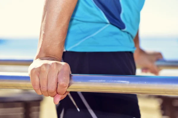 Joven deportista haciendo salsas en barras paralelas — Foto de Stock