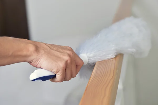 Jovem espanando a casa com um espanador de microfibra — Fotografia de Stock