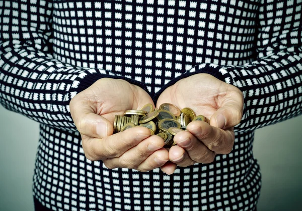 Jeune homme avec des pièces en euros dans ses mains — Photo