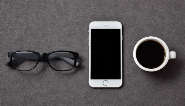 Eyeglasses, smartphone and cup of coffee — Stock Photo, Image