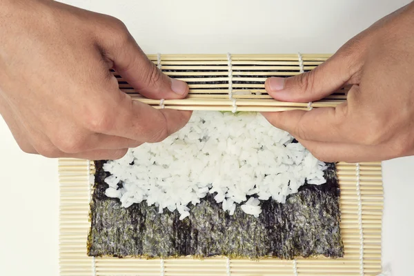 Joven hombre preparando makizushi — Foto de Stock