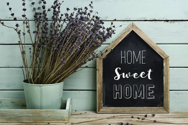 Tekst home sweet home in een huis-vormige uithangbord — Stockfoto