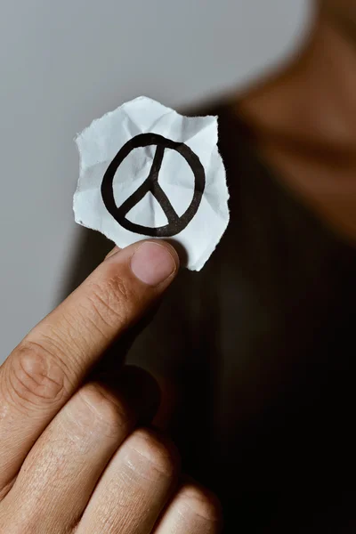 Homem com um símbolo de paz num pedaço de papel — Fotografia de Stock