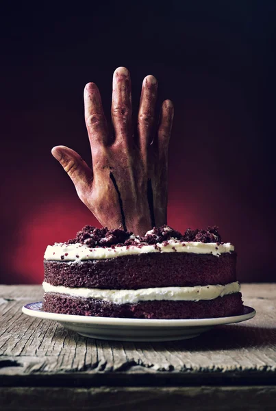 Cadılar Bayramı için korkunç bir sahnede kanlı bir el ile tepesinde kek — Stok fotoğraf