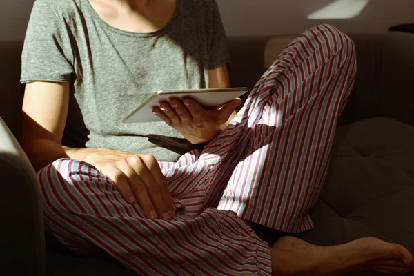 Jeune homme en pyjama à l'aide d'une tablette — Photo