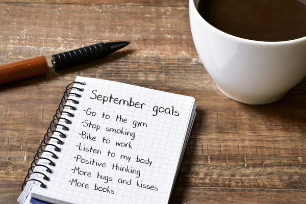 Coffee and notepad with a list of September goals — Stock Photo, Image