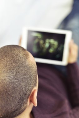 genç adam bir film ya da onun tableti bir dizi izlerken