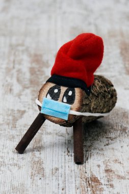 El yapımı bir tio de nadal, tipik bir katalonya, İspanya, beyaz, ahşap bir yüzeyde yüz maskesi takan noel karakteri.