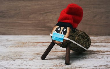 El yapımı bir tio de nadal, tipik bir katalonya, İspanya, beyaz, ahşap bir yüzeyde yüz maskesi takan noel karakteri.