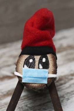 El yapımı bir tio de nadal, tipik bir katalonya, İspanya, beyaz, ahşap bir yüzeyde yüz maskesi takan noel karakteri.
