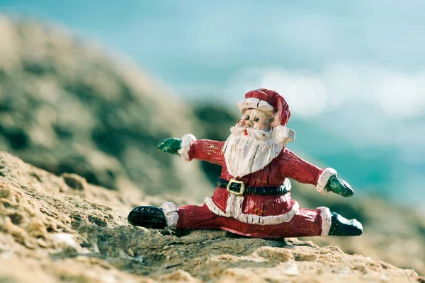 Figurka Świętego Mikołaja Rozłamie Skale Naturalnym Krajobrazie Oceanem Tle — Zdjęcie stockowe