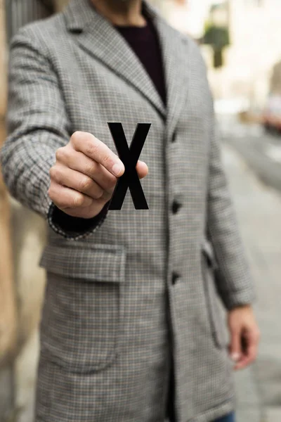 在第三个性别类别中 站在街头 穿着一件带有X的外套的年轻高加索人的特写镜头 — 图库照片
