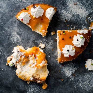 Bazı parçaların yüksek açılı görüntüsü ve gri bir taş yüzeyde tereyağlı kremayla süslenmiş krema artığı.