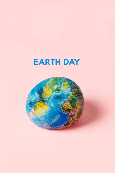 ピンク色の背景に包まれた柔らかい地球とテキストの地球の日 — ストック写真