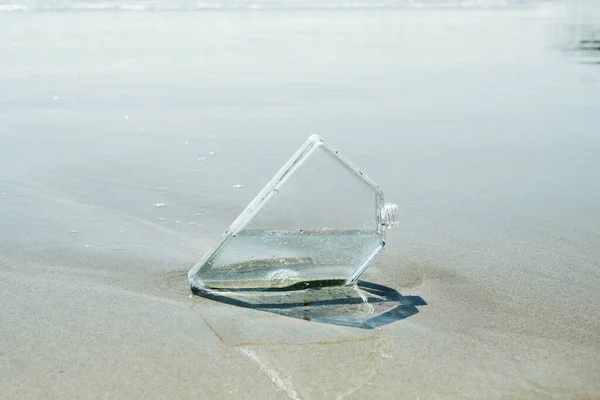 孤独なビーチの海岸の湿った砂の上にある長方形の再利用可能な水ボトルの閉鎖 — ストック写真