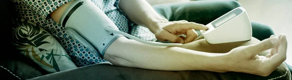 Closeup Caucasian Man Sitting Sofa Measuring His Own Blood Pressure — Stock Photo, Image