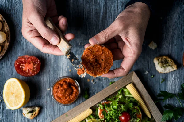 Giovane Caucasico Diffonde Una Diffusione Vegana Fatta Con Pomodoro Essiccato — Foto Stock