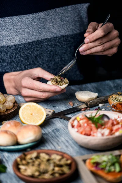 Young Caucasian Man Sitting Gray Rustic Wooden Table Puts Some — Stock Photo, Image