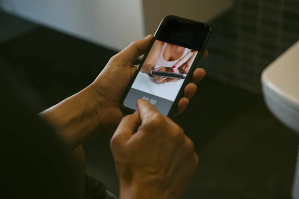 トイレに座っている白人男性のクローズアップ 日付彼のスマートフォンでオンライン その画面にモックアプリで — ストック写真