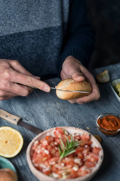 Closeup Young Caucasian Man Cutting Bread Bun Prepare Sandwich Sitting — Stock Photo, Image