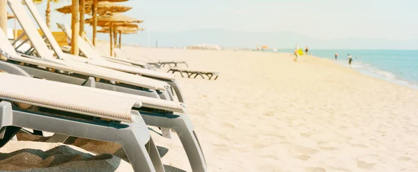 在安静的海滩上 一些米色的日光浴者和一些遮阳伞的特写镜头 以全景形式使用 作为网页横幅或标题 — 图库照片