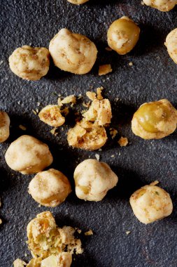 Koyu gri bir taş yüzeyde biraz kızarmış bezelye yakın.