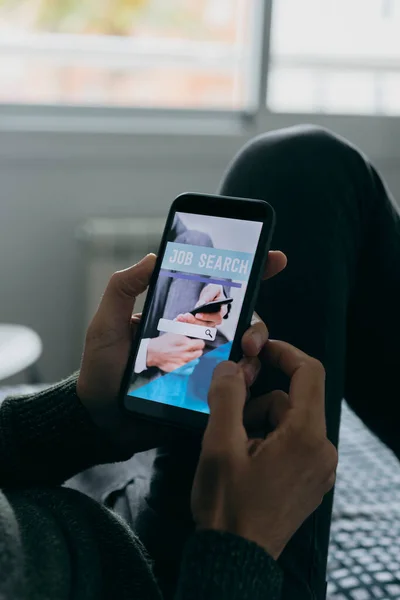 Mladý Muž Doma Hledá Práci Line Svým Smartphonem Simulovaným Vyhledávačem — Stock fotografie