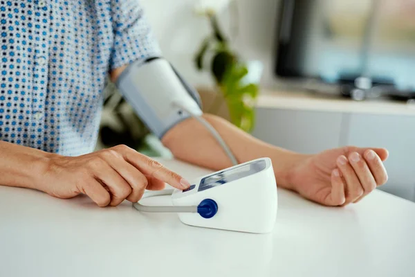 Närbild Kaukasisk Man Mäter Sitt Blodtryck Med Elektronisk Blodtrycksmätare Sitter — Stockfoto