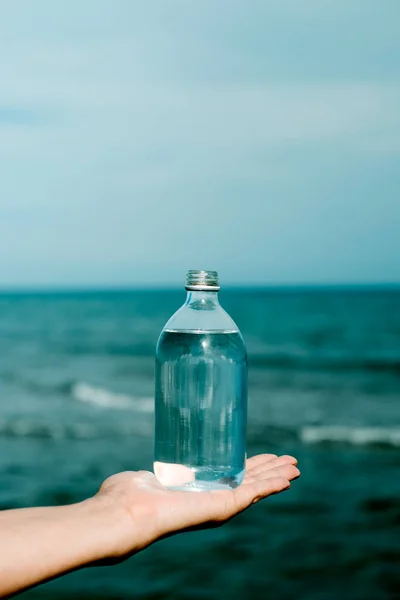 Ένας Νεαρός Καυκάσιος Κρατάει Ένα Γυάλινο Μπουκάλι Γεμάτο Νερό Στην — Φωτογραφία Αρχείου