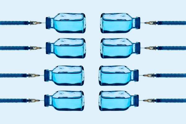 Some Vaccine Vials Blue Liquid Some Syringes Stuck Them Arranged — Stock Photo, Image