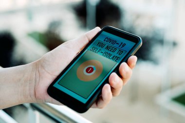 Kafkasyalı genç bir adam, evinde, akıllı telefonundan bir uyarı alır. Sahte bir covid-19 iletişim takip uygulamasından.