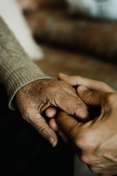 一个年轻的高加索男人牵着一个年长的高加索女人的手 充满爱心 — 图库照片