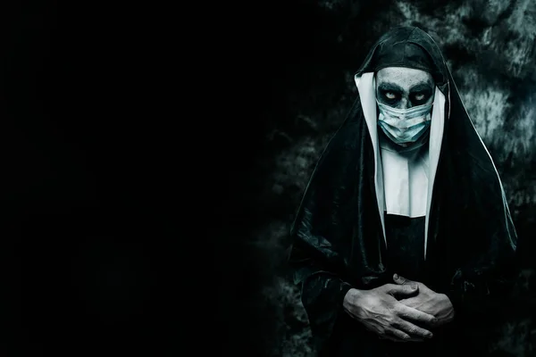 一个可怕的邪恶修女 穿着典型的黑白相间的习惯 戴着一次性的面具 在黑色的背景上 左边有一些空白的地方 — 图库照片