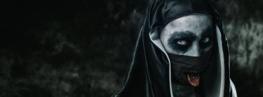 Siyah-beyaz giysili korkunç bir rahibe, siyah yüz maskesi içindeki delikteki dilini dışarı çıkarıyor, panoramik bir formatta web pankartı ya da başlığı olarak kullanıyor.