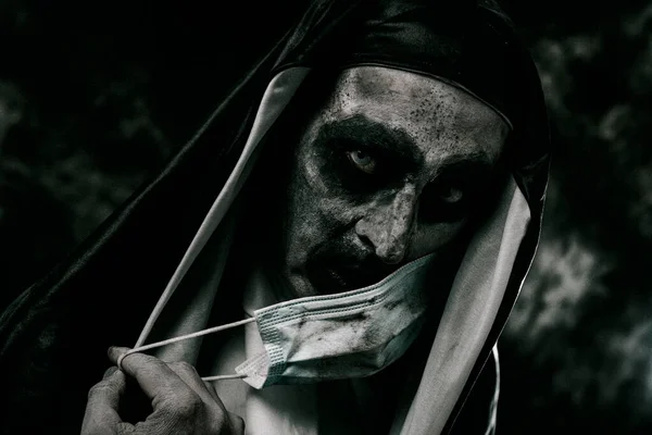 一个可怕的邪恶修女 穿着黑白相间的衣服 用肮脏的一次性口罩捂住了她的嘴 — 图库照片