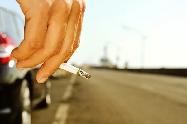 Homem fumando em uma estrada sem trânsito — Fotografia de Stock