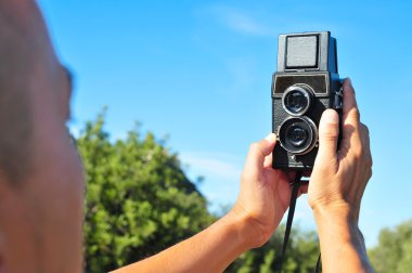 genç adam yaşlı bir orta format fotoğraf makinesi ile bir selfie alarak