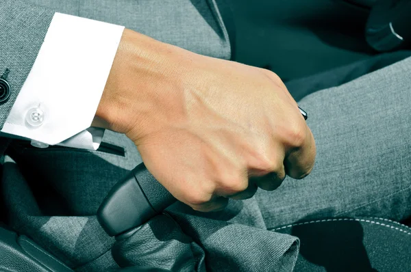 Man in suit pulling the hand brake of a car — Stock Photo, Image