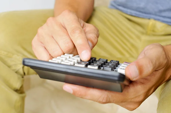 Jeune homme utilisant une calculatrice — Photo