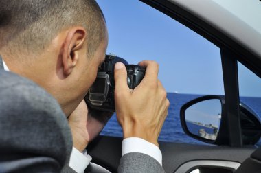 detective or a paparazzi taking photos from inside a car clipart